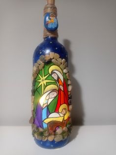 a blue bottle with a nativity scene painted on it