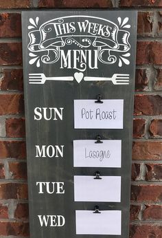 a sign on the side of a brick wall that says this week's menu