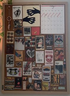 a bulletin board covered in stickers and magnets next to a potted plant