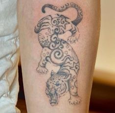 a tattoo on the leg of a person with a tiger in it's body