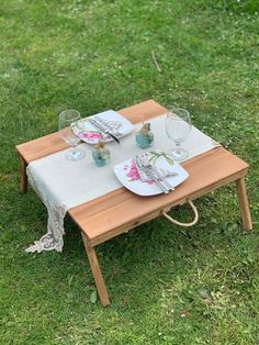 a table set with place settings for two on the grass