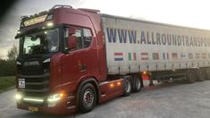 a red semi truck driving down a road