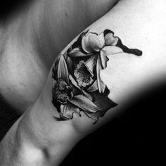 a black and white photo of a woman's arm with a flower tattoo on it