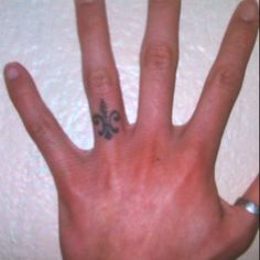 a hand with a four leaf clover tattoo on it's left thumb and fingers