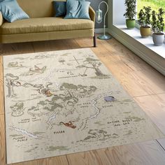 a living room area with a couch, chair and map rug on the hardwood floor