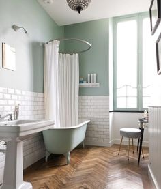 a bathroom with a tub, sink and mirror