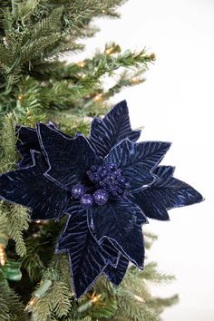 a close up of a blue flower on a christmas tree