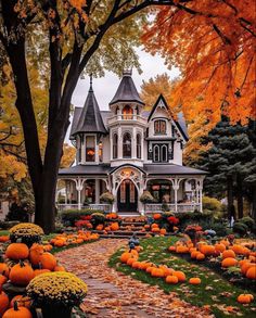 a large house with lots of pumpkins in the front yard and trees around it