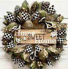 a wreath with the words home sweet home written in white and black letters on it