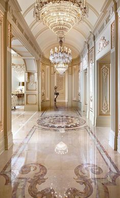 an ornate hallway with chandelier and marble flooring in a palace like setting