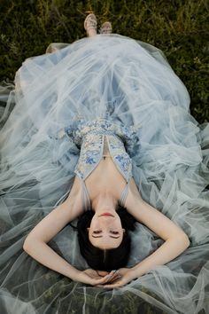 a woman laying on the ground wearing a blue dress