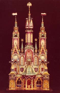 an elaborately designed model of a building with clocks on it's sides and spires