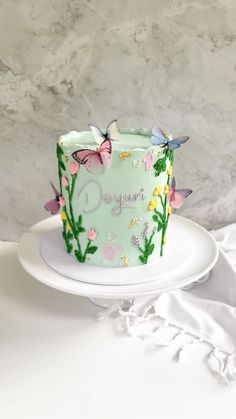 a birthday cake decorated with butterflies and flowers