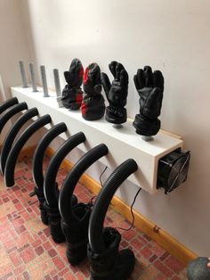 several pairs of black gloves are lined up on a shelf next to a blow dryer