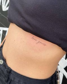 a woman's stomach with the word love yourself written on it, in cursive font