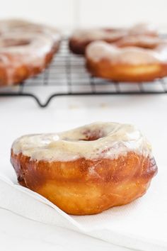 two glazed donuts sitting on top of a white napkin