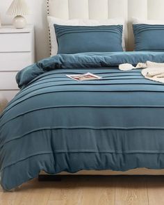 a bed with blue sheets and pillows on it