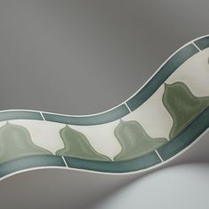 a green and white curved dish on a gray background