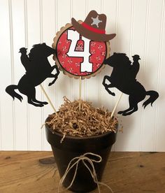 a number four cake topper sitting on top of a pot filled with dried grass