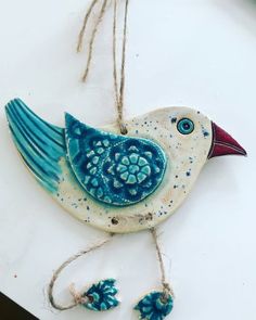 a blue and white bird hanging from a string on top of a table next to other items