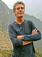 a man standing on top of a mountain with his arms crossed in front of him