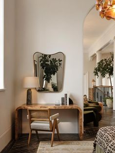 a living room with a couch, chair and mirror on the wall next to it