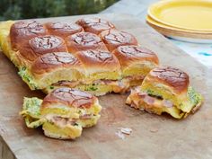 a sandwich cut in half sitting on top of a cutting board next to a plate