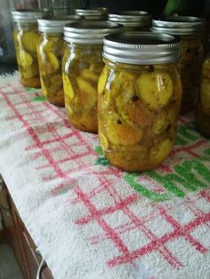 several jars filled with pickles sitting on top of a table