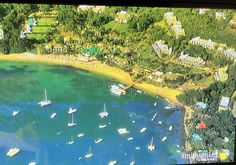 an aerial view of boats in the water and houses on the land behind them,