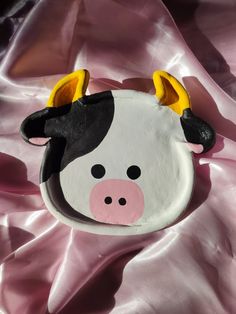 a cow mask is laying on a pink sheet