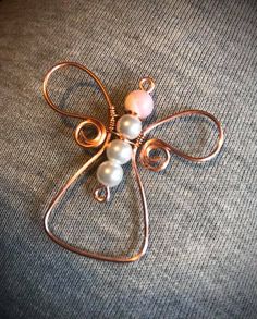 a brooch with pearls on it sitting on top of a gray fabric covered surface