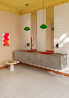 an empty bathroom with two sinks and three lights hanging from the ceiling over it's counter