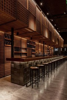 an empty bar with stools and wooden shelves