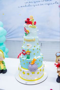 a blue and white cake sitting on top of a table next to other toy figurines