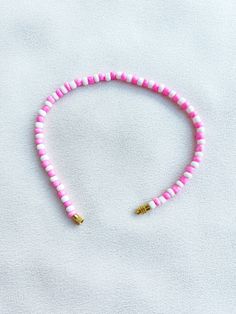 Handcrafted white and pink beaded anklet/bracelet. Made using small colourful round glass beads and finished with a gold-plated barrel clasp closure. Pair it with our matching Necklace.  * Weight: 7g   * Width: 5mm/2mm  * Made in UK  * Code: 111AWPS The very best in unique, handmade pieces from BAM-BAM, our anklets and bracelets make great accessories for the beach, festival or club. These small beads have a dainty appearance and can take your best looks from day to night. Adjustable Pink Anklet With Colorful Beads, Adjustable Pink Single Strand Beaded Bracelets, Adjustable Pink Single Strand Beaded Bracelet, Adjustable Single Strand Pink Beaded Bracelet, Pink Spacer Beads For Beach, Pink Heishi Beads For Beach, Single Strand Pink Round Beads, Pink Round Beaded Bracelets For Beach, Adjustable Pink Heishi Beads