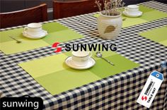 the table is set with two cups and saucers on it, along with an ad for sunwing