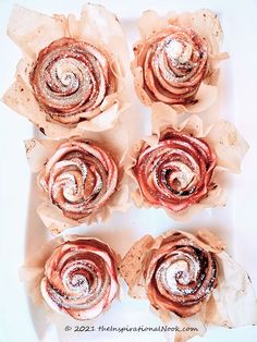 four cinnamon roll flowers sitting on top of a white plate