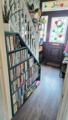 a stair case filled with lots of books next to a window on the side of a staircase