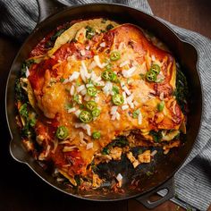 a skillet filled with chicken, cheese and vegetables