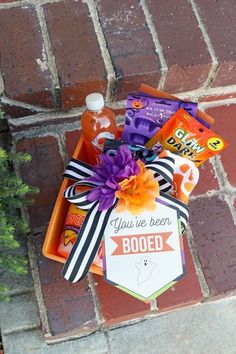 a halloween treat box with candy, booze and candies in it sitting on a brick walkway