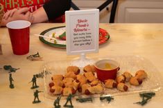 a plastic container filled with food sitting on top of a table next to a sign