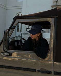 a woman sitting in the driver's seat of a pickup truck looking out the window