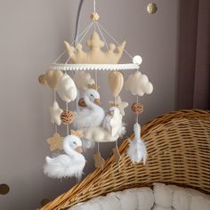 a baby crib mobile with ducks and swans hanging from it