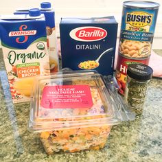 some food is sitting on top of a counter next to two containers and one container