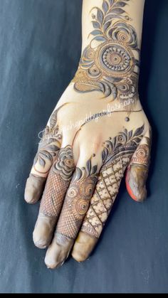 the hands and feet of a woman with henna designs on their palms, showing intricate patterns