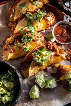 tortillas with salsa and guacamole on the side are ready to be eaten