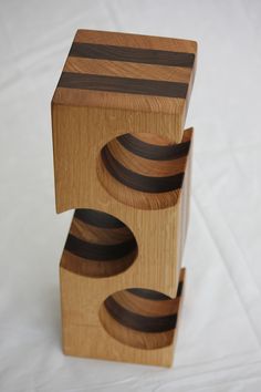 three wooden boxes stacked on top of each other with black and brown stripes in them