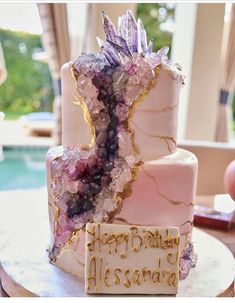 a pink and gold birthday cake with crystals on it