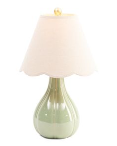 a green table lamp with a white shade