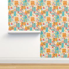 an orange and blue wallpaper with flowers on it next to a wooden floor in front of a white wall